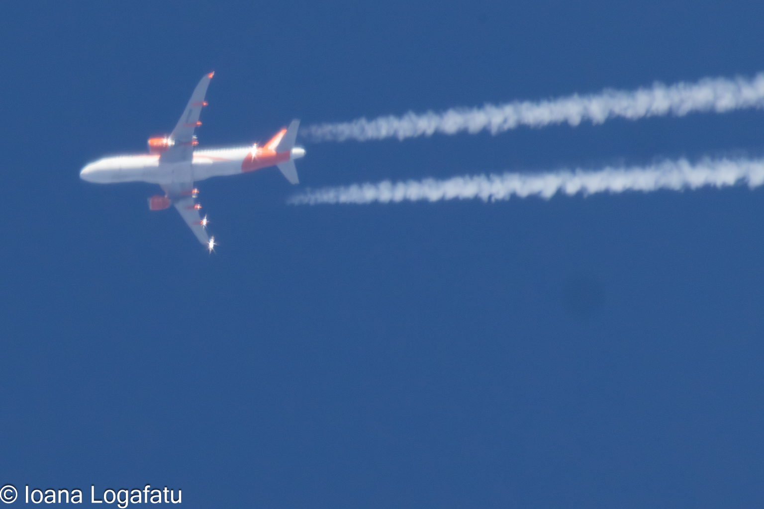 High-flying aircraft leaving trails in blue sky